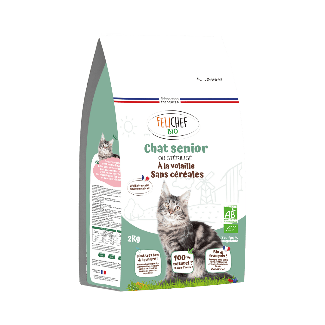 Un sac de croquettes sans céréales bio pour chat sénior est au centre de l’image. Le sac vert de 2 kg contient des croquettes naturelles saveur volaille. Le fond est blanc.
